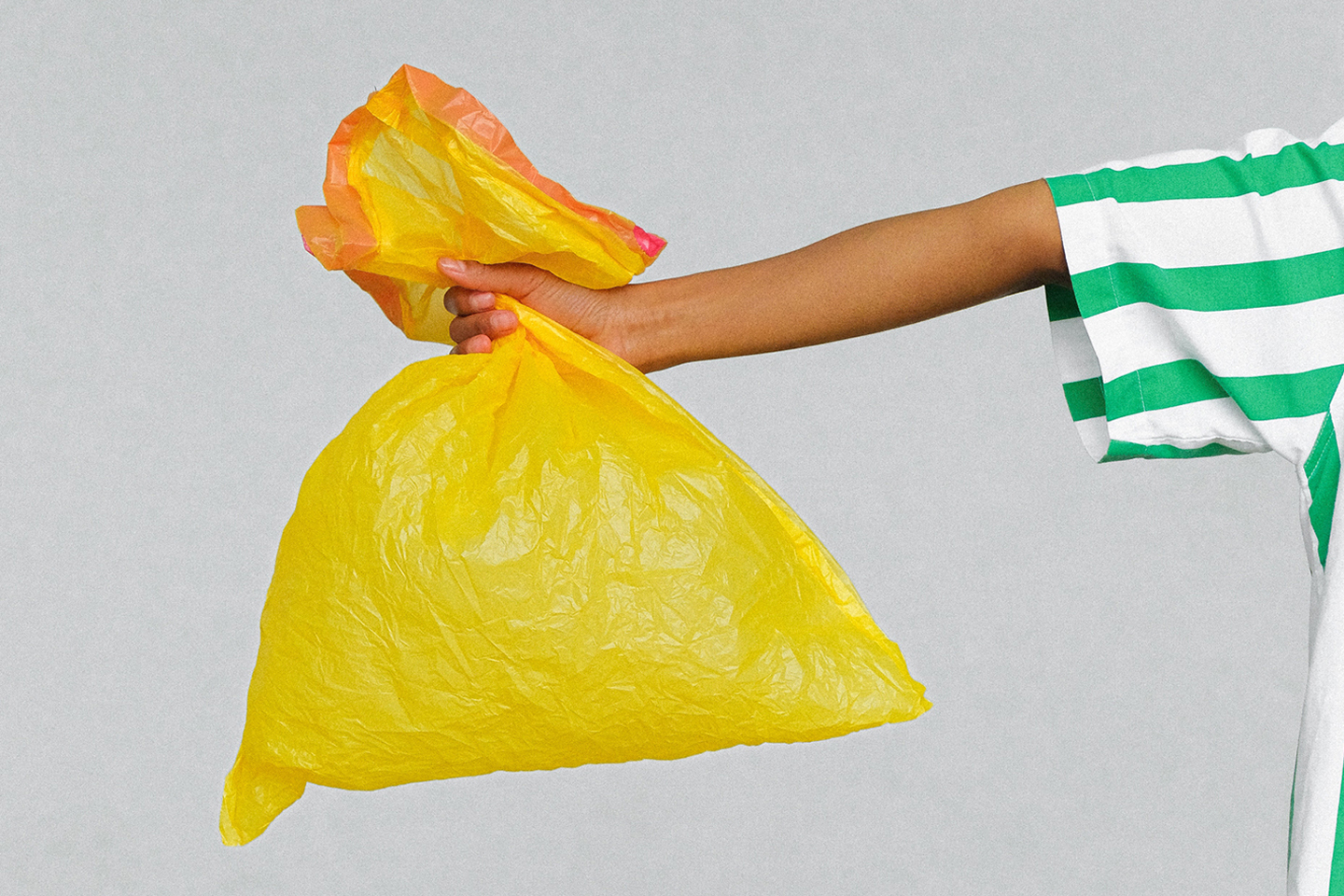 image of a person holding a bag of trash