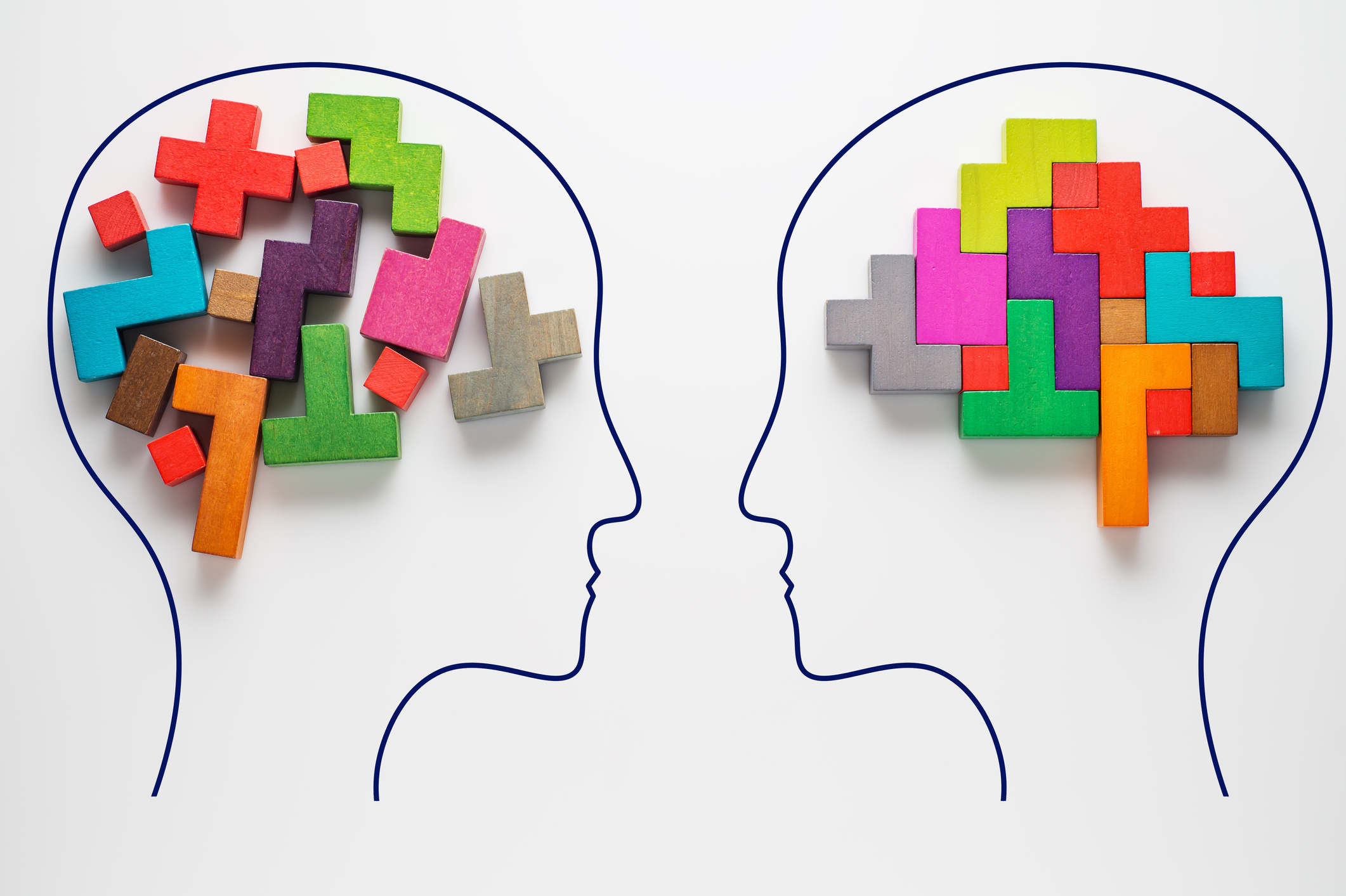 a graphic of two faces looking at one another, one with disordered blocks within the brain and the other with orderly blocks