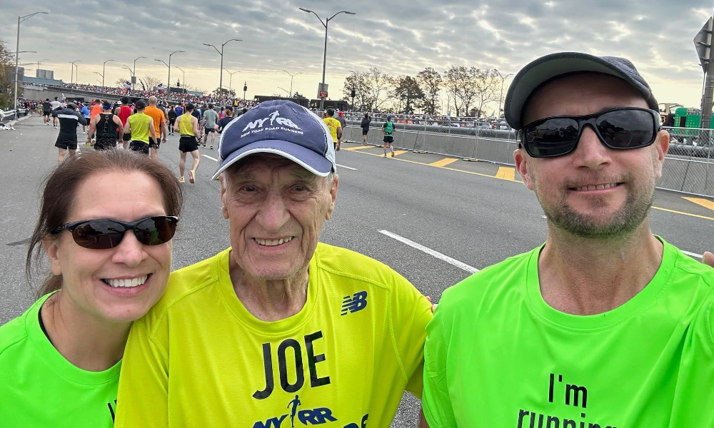 image of joe dornicik at the finish line of a marathon standing with two other runners