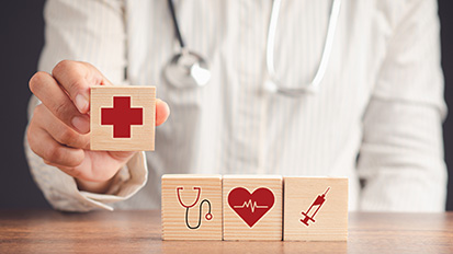 hands holding blocks with public health symbols