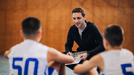 Coach with young basketball players